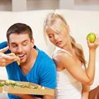 Un homme de manger des aliments et une femme regardant manger tout en tenant une pomme