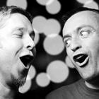 Une photo en noir et blanc de deux hommes en chantant