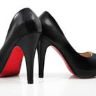 Une paire de chaussures à talons noires avec un fond rouge