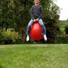 Un enfant assis sur une boule rouge