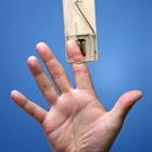 Le doigt d'une personne coincé à l'intérieur d'un piège à souris