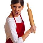 Une femme tenant un rouleau à pâtisserie avec sa bouche ouverte