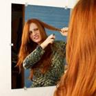 Femme aux cheveux rouge coupe de cheveux dans le miroir