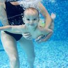 Une femme tenant un enfant comme il nage