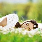 Jeune fille endormie dans l'herbe avec des fleurs